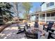 Landscaped backyard features a circular brick fire pit with adirondack chairs, and mature trees at 15962 E Lehigh Cir, Aurora, CO 80013