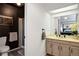 Bathroom featuring a dark accent wall and a shower, conveniently located adjacent to the main bedroom at 15962 E Lehigh Cir, Aurora, CO 80013