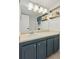 Bathroom featuring a vanity, large mirror with shelving, and a white tiled shower behind the door at 1441 N Humboldt St # 505, Denver, CO 80218