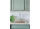 Bright kitchen features a modern faucet, sink, and green cabinetry at 1441 N Humboldt St # 505, Denver, CO 80218