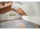 Unfinished attic featuring exposed beams, small window offering natural light, and unfinished floor at 4536 Beach Ct, Denver, CO 80211