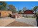 A backyard with gravel landscaping, bordered by a brick building and detached garage with a red-painted roof at 4536 Beach Ct, Denver, CO 80211