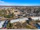 Wide aerial shot of an apartment complex with mature trees, streets, and a view of the city in the distance at 650 S Clinton St # 6D, Denver, CO 80247