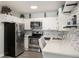 Kitchen featuring stainless steel appliances, white cabinets, white countertops, and backsplash at 650 S Clinton St # 6D, Denver, CO 80247