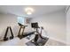 Bright home gym with a peloton, treadmill, weight rack, and a large window at 6931 W 75Th Pl, Arvada, CO 80003