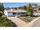 Charming single-story home with gray siding, white trim, and a covered front porch with lush landscaping at 2610 Heidelberg Dr, Boulder, CO 80305