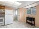 Kitchen with white appliances and access to the back door and a black side table at 2610 Heidelberg Dr, Boulder, CO 80305