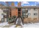 A condo complex with a wooden walkway leading to the entrance, featuring brick and siding accents at 14652 E 2Nd Ave # 200D, Aurora, CO 80011