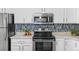 Close up of the kitchen appliances, showcasing the stove, oven, and a stylish backsplash design at 14652 E 2Nd Ave # 200D, Aurora, CO 80011