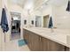Bathroom with double sink vanity, a view of a walk-in closet, and white tiles at 4537 N Tennyson St # 101, Denver, CO 80212