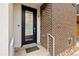 A charming townhome front door features a modern black-framed glass door with a unique brick facade at 4537 N Tennyson St # 101, Denver, CO 80212