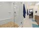 Modern tiled shower with glass door and a view into a walk-in closet at 4537 N Tennyson St # 101, Denver, CO 80212