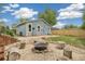 Landscaped backyard with a sand firepit and tree stump seating, and fenced perimeter at 280 Pierce St, Erie, CO 80516