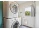 Convenient laundry room featuring stacked washer and dryer with a door to access the backyard at 280 Pierce St, Erie, CO 80516