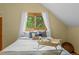Bedroom with hardwood floors, comfortable bed, and views of the treelined backyard at 420 Chinook Rd, Idaho Springs, CO 80452