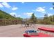 Relaxing deck space with lounge chairs and views of the distant mountains beyond the trees at 420 Chinook Rd, Idaho Springs, CO 80452