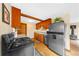 Well-lit kitchen with stainless steel appliances and wood cabinets, adjacent to living room with fireplace at 420 Chinook Rd, Idaho Springs, CO 80452