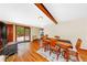 Bright living room with wood-burning stove, hardwood floors, dining table, and access to deck at 420 Chinook Rd, Idaho Springs, CO 80452