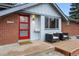 Close up of front entrance with modern red door, cozy porch furniture, and manicured landscaping at 2958 E Euclid Pl, Centennial, CO 80121