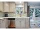 Bright kitchen with white cabinets, stainless steel dishwasher and a view to an outdoor patio space at 2958 E Euclid Pl, Centennial, CO 80121
