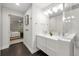 Modern bathroom featuring a double vanity with sleek white cabinets and a glass-enclosed shower at 9861 E Ohio Ave, Denver, CO 80247