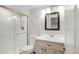 Bright bathroom features a tiled shower with glass door and a vanity with a framed mirror at 9861 E Ohio Ave, Denver, CO 80247