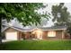 Charming brick home with attached garage and lush front yard, with mature trees providing shade at 9861 E Ohio Ave, Denver, CO 80247