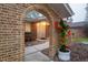 Charming brick front entrance with arched doorway and vibrant red flowers in a decorative planter at 9861 E Ohio Ave, Denver, CO 80247