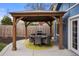 Backyard with covered patio, outdoor dining set, and a built-in grill for entertaining at 7282 S Vance St, Littleton, CO 80128