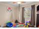 Bright bedroom with a ceiling fan, window with curtains, and colorful alphabet floor mat at 7282 S Vance St, Littleton, CO 80128