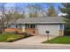 Charming single-story home featuring a well-manicured lawn, brick accents, and a paved driveway at 7282 S Vance St, Littleton, CO 80128