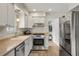 Bright kitchen equipped with modern stainless steel appliances and white cabinetry at 7282 S Vance St, Littleton, CO 80128