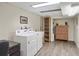 Well-equipped laundry area with washer, dryer, shelving, and a utility sink for added convenience at 7282 S Vance St, Littleton, CO 80128