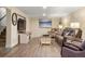 Spacious living room featuring modern flooring, comfortable seating, and a large flat-screen TV at 7282 S Vance St, Littleton, CO 80128