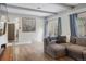 Bright living room with hardwood floors, a ceiling beam, and access to the dining room at 7282 S Vance St, Littleton, CO 80128