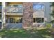 Close up of ground floor unit with stone accents, outdoor living space, and mature trees at 3365 Chisholm Trl # B102, Boulder, CO 80301