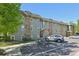 Low angle view of a well-maintained condo building with stone details and parking in front at 3365 Chisholm Trl # B102, Boulder, CO 80301