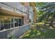 View of a well-maintained condo building, mature trees, and outdoor patio space at 3365 Chisholm Trl # B102, Boulder, CO 80301