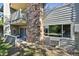 Patio and stone detail on condo with siding and landscaped yard including mature trees at 3365 Chisholm Trl # B102, Boulder, CO 80301
