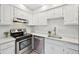 Bright kitchen features white cabinets, stainless steel appliances, and quartz countertops at 3365 Chisholm Trl # B102, Boulder, CO 80301