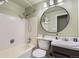 Neat bathroom featuring tile shower-over-tub, round mirror, white fixtures, and green walls at 4665 E Peakview Ave, Centennial, CO 80121