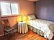Cozy bedroom with hardwood floors, a comfortable twin bed, a bedside table and chair, and a bright window at 4665 E Peakview Ave, Centennial, CO 80121