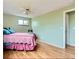 A spacious bedroom features hardwood floors, a comfy bed, and a large window offering plenty of natural light at 4665 E Peakview Ave, Centennial, CO 80121