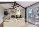 Cozy living room with a brick fireplace, wood-beam ceiling, and sliding glass doors at 4665 E Peakview Ave, Centennial, CO 80121