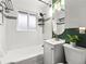 Bathroom with white tiled walls, a bathtub, and a stylish vanity with a round mirror at 3555 Leyden St, Denver, CO 80207