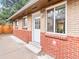 Brick home exterior with a white door and windows under an overhanging roof at 3555 Leyden St, Denver, CO 80207