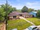 Well-maintained brick home featuring a long driveway, fenced yard, and mature landscaping at 3555 Leyden St, Denver, CO 80207