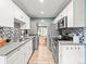 Modern kitchen with white cabinets, updated appliances, and a mosaic backsplash at 3555 Leyden St, Denver, CO 80207