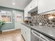 Well-lit kitchen with stainless steel appliances, modern backsplash, and wood-look flooring at 3555 Leyden St, Denver, CO 80207