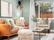 Cozy living room featuring a leather sofa, decorative pillows, and large window views at 3555 Leyden St, Denver, CO 80207